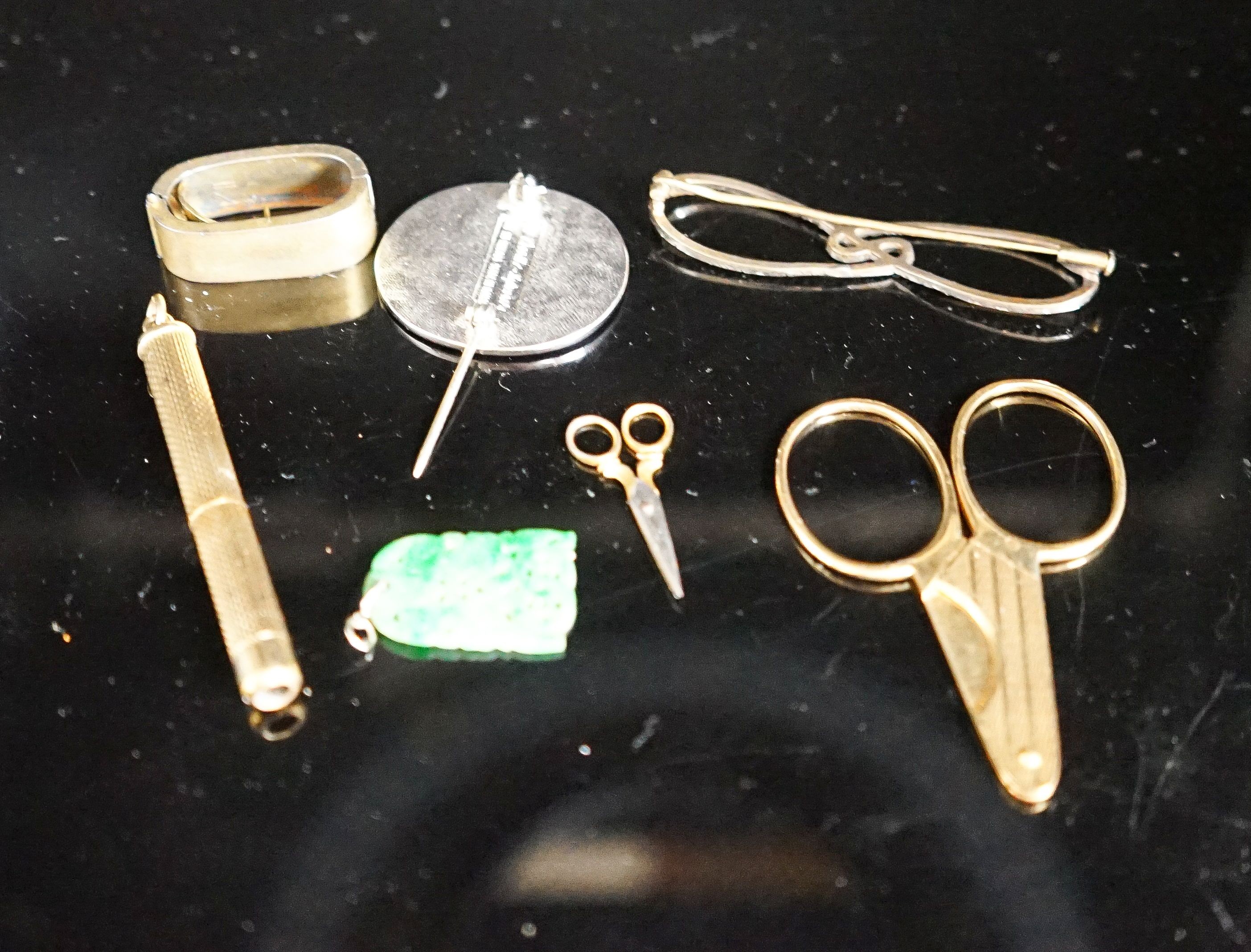 Mixed jewellery including an 18ct cigar cutter, 5cm, 7.9 grams, an engine turned 9ct gold propelling tooth pick, a jade pendant, scarf clip etc.